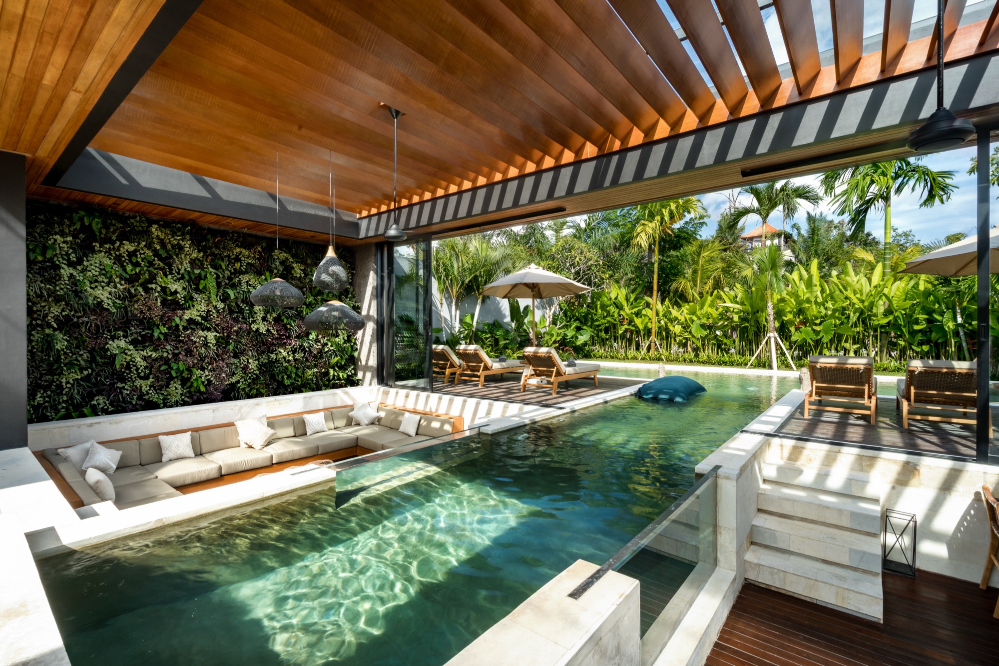 Salon de la Villa Beltza avec piscine intégrée, mur végétal et luminaires en rotin — Pengosekan, Ubud, Bali