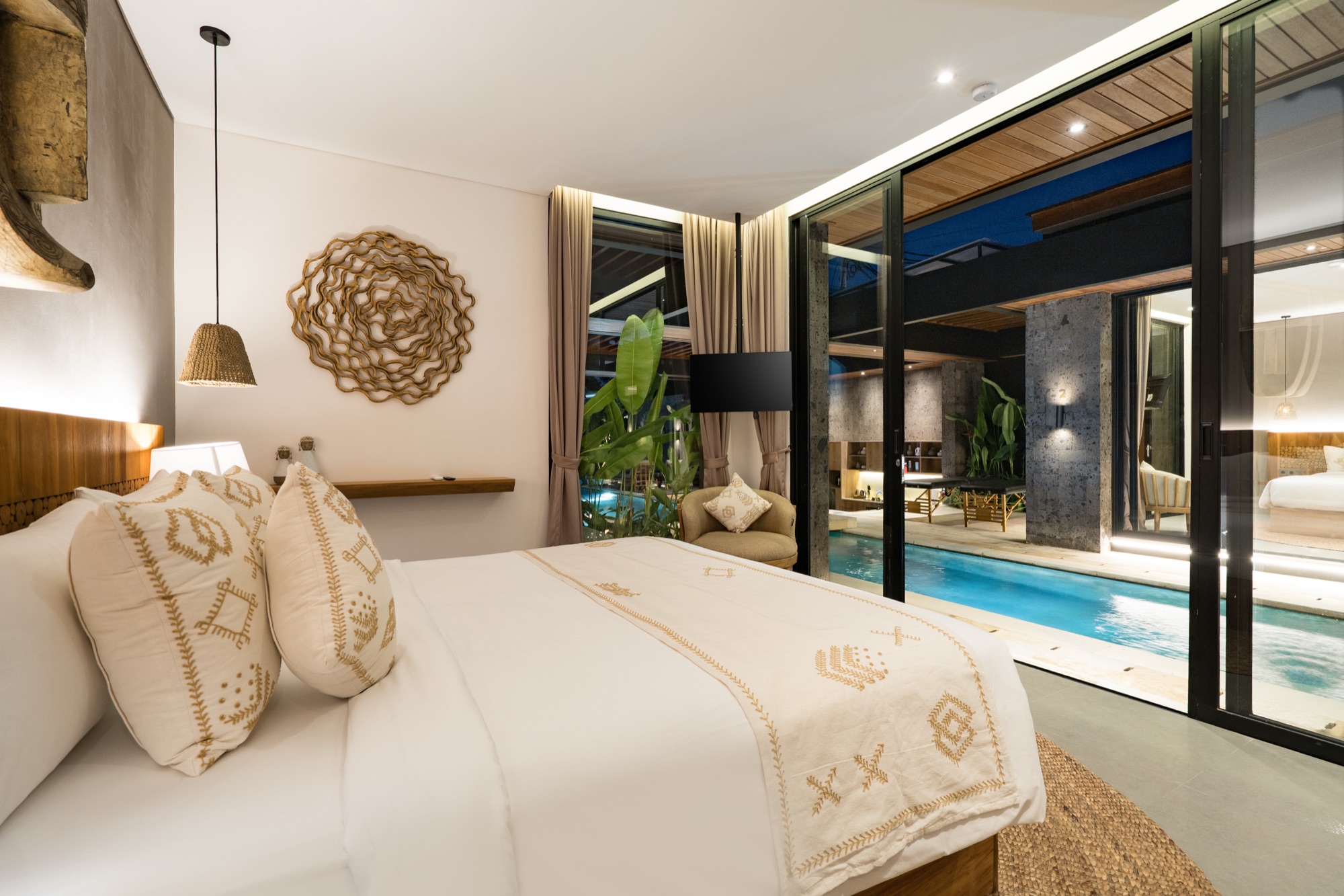 Suite de Villa Beltza la nuit — vue panoramique sur la piscine illuminée depuis le lit