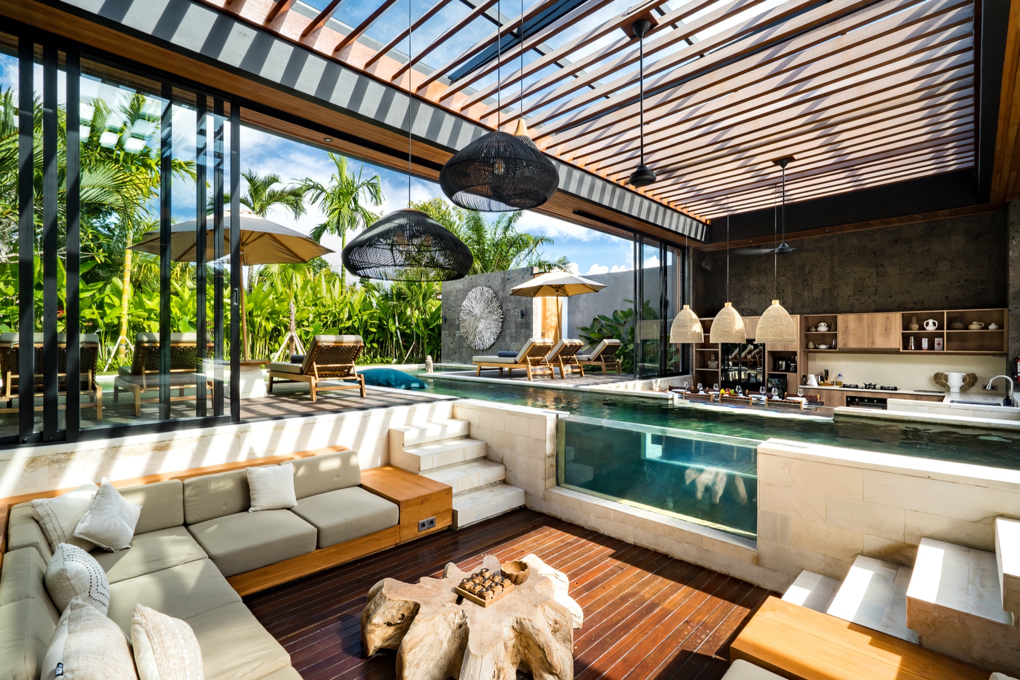 Salon ouvert de Villa Beltza avec piscine couloir, cuisine ouverte et jardin tropical