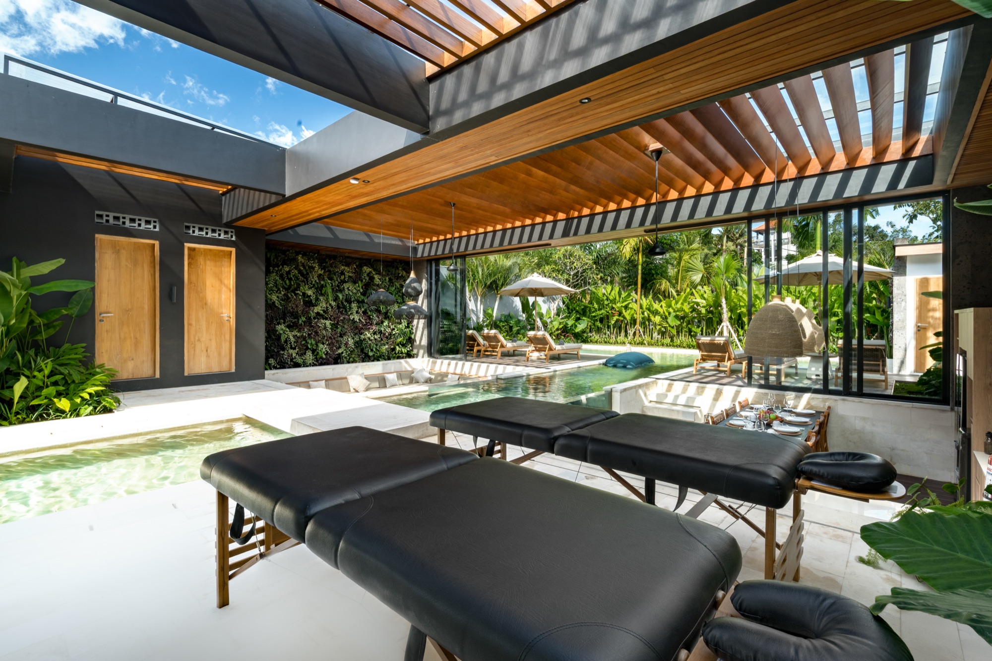 Espace massage de Villa Beltza — tables de massage balinais au bord de la piscine sous pergola en teck