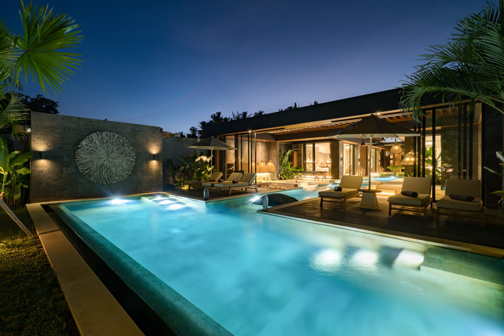 Piscine nocturne de Villa Beltza Ubud Bali — ciel étoilé, transats illuminés et palmiers